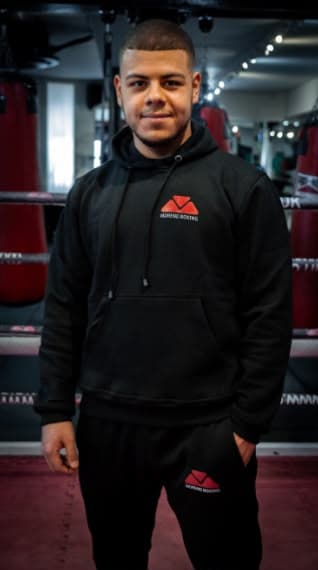 Person wearing a black Moreno Boxing hoodie in the boxing gym